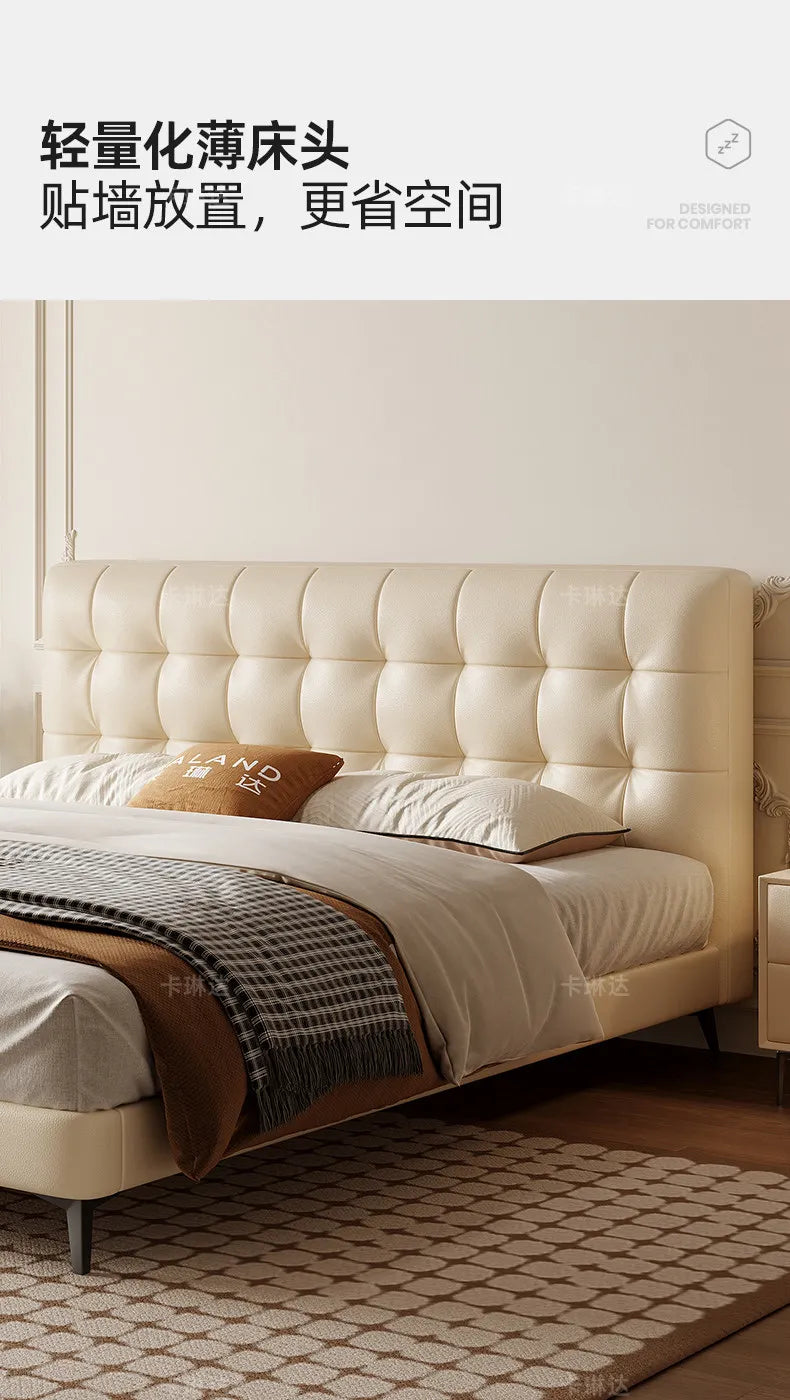 Minimalist cream bed frame with a slim, tufted headboard and sleek dark legs in a bright, modern bedroom setting.