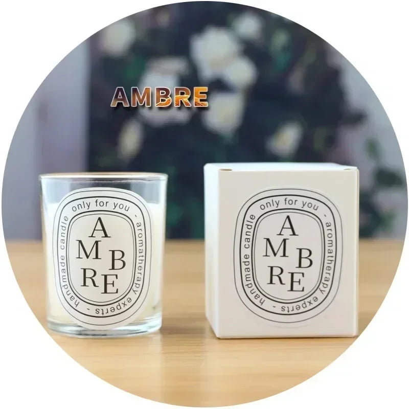 Ambre scented handmade aromatherapy candle in a clear glass votive with matching white gift box.
