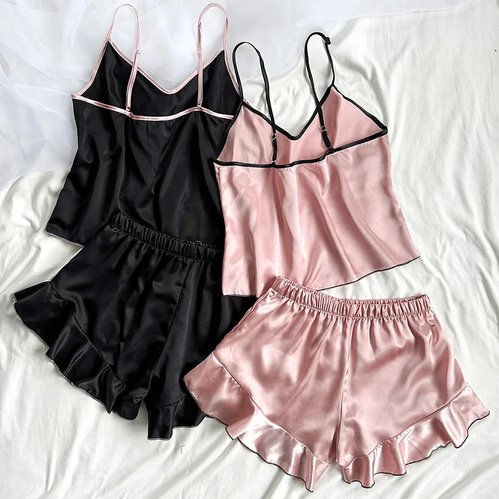 Two satin pyjama sets in black and dusty pink, featuring camisole tops and ruffled shorts with contrast trim.