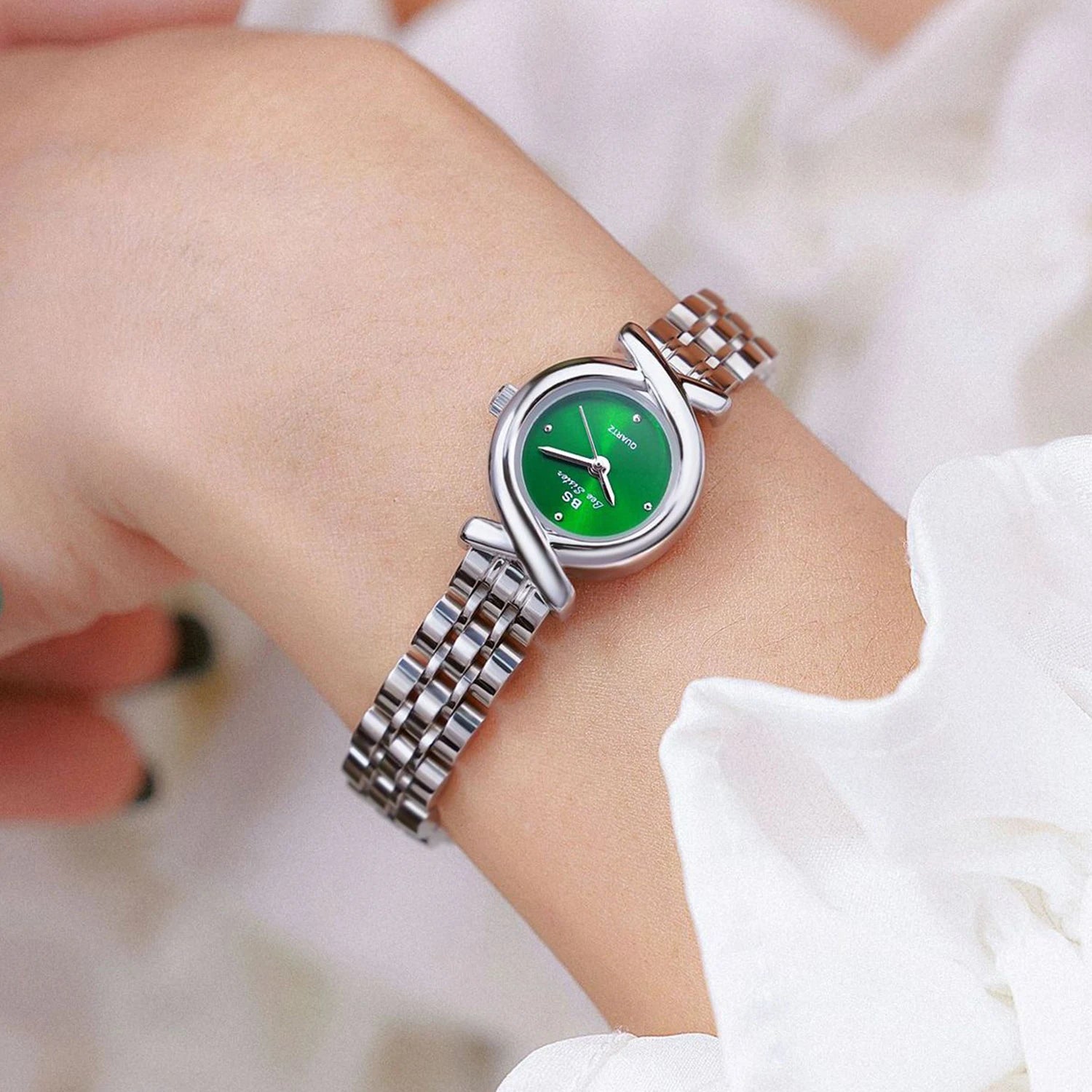 Elegant women's quartz wristwatch with a vibrant green dial and a polished silver stainless steel crossover strap.