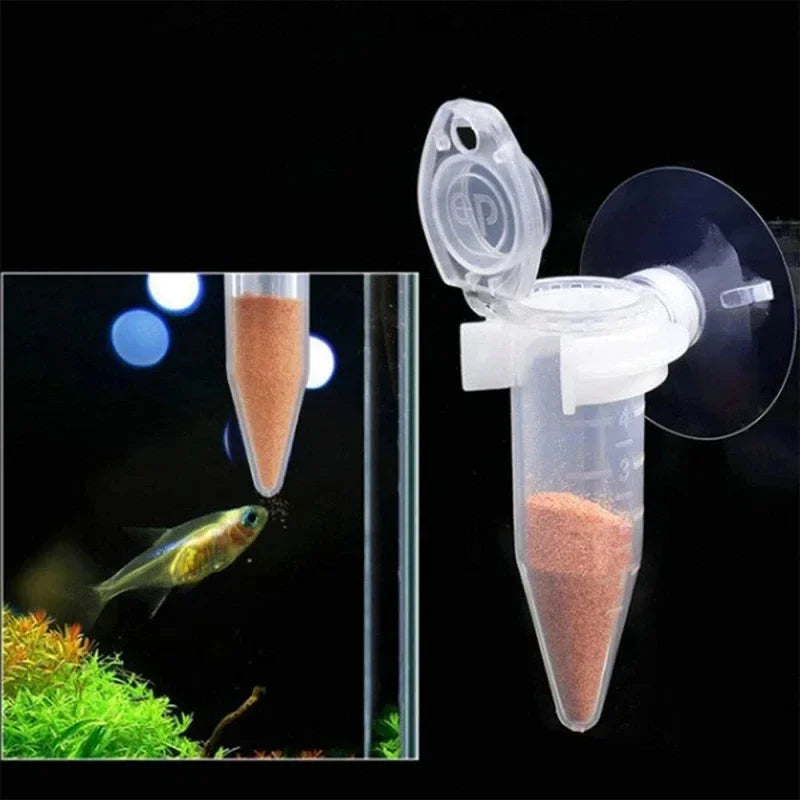 Clear plastic cone-shaped fish feeder with suction cup, attached to a glass aquarium wall for dispensing fish food.