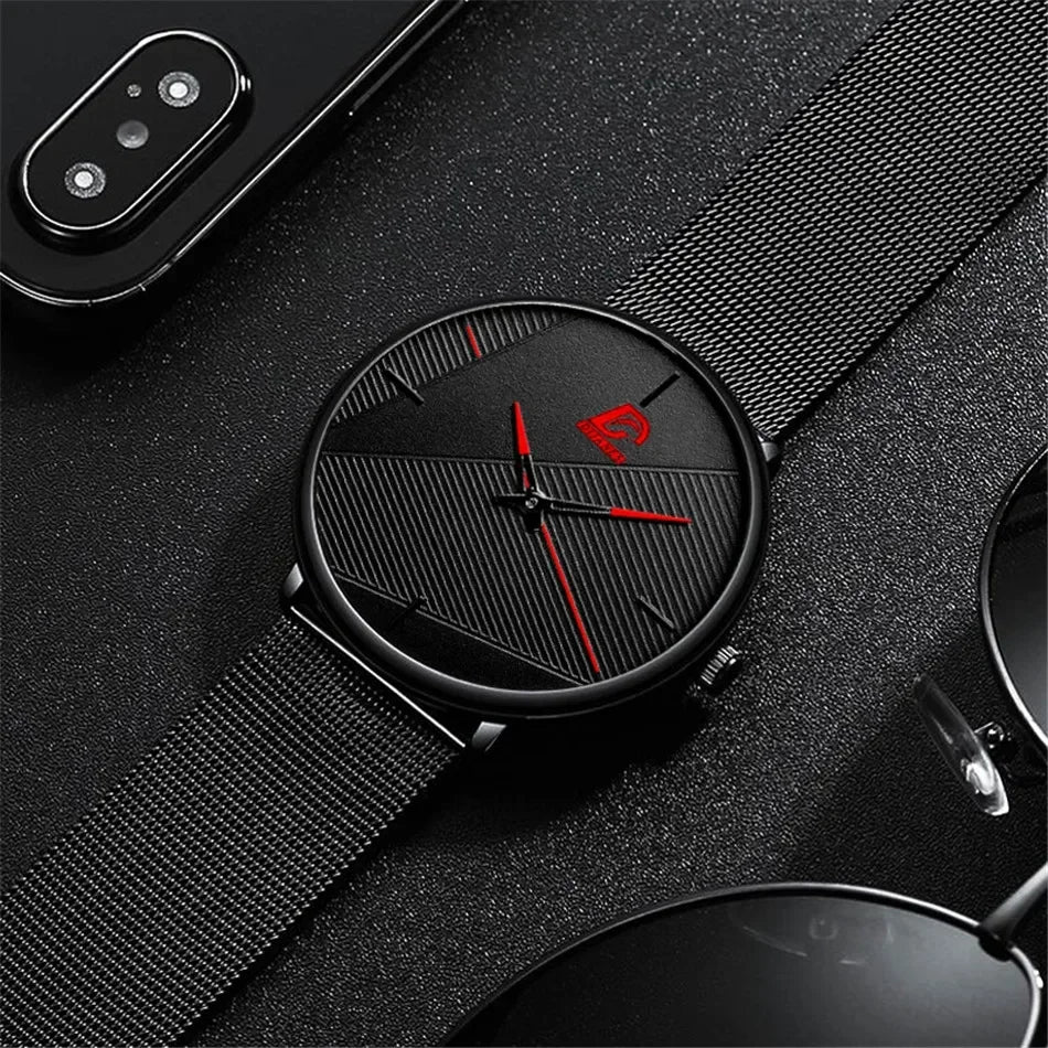 Minimalist men’s ultra-thin quartz watch with a black mesh strap, textured black dial and striking red hands.