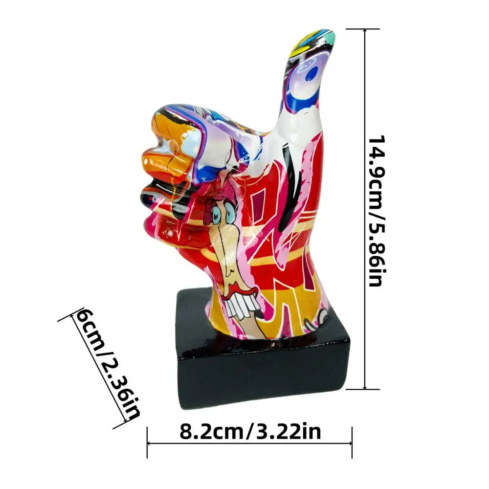 Abstract thumbs-up hand ornament with vibrant graffiti-style art on a black square base. Dimensions shown.