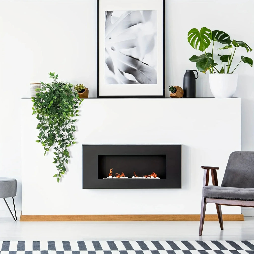 Trailing artificial green ivy vines draped over a minimalist white fireplace mantle.