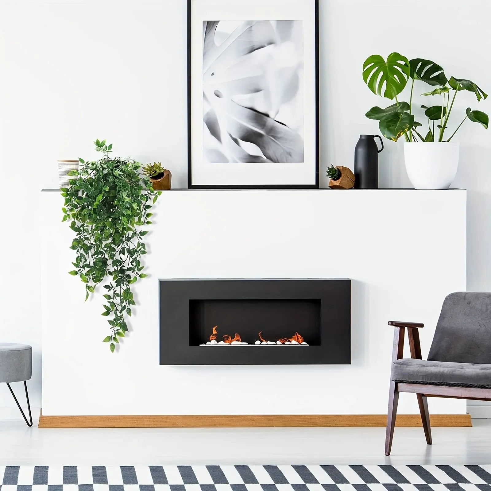 Trailing artificial green ivy vines draped over a minimalist white fireplace mantle.