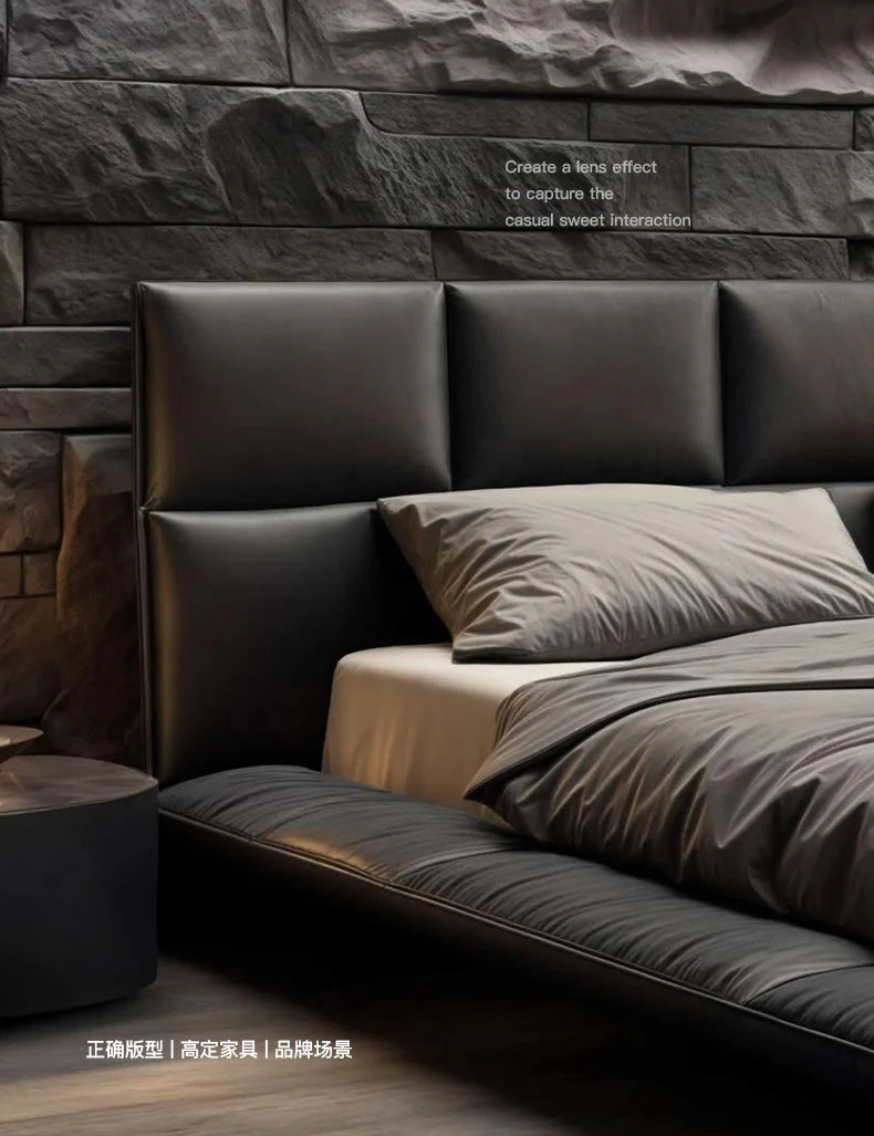 Modern black leather king-size floating bed with a structured, panelled headboard against a textured stone wall.