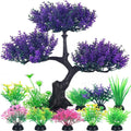 An artificial aquarium bonsai tree with purple foliage and several small colorful plastic plants on black bases.