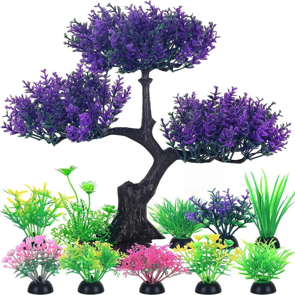 An artificial aquarium bonsai tree with purple foliage and several small colorful plastic plants on black bases.