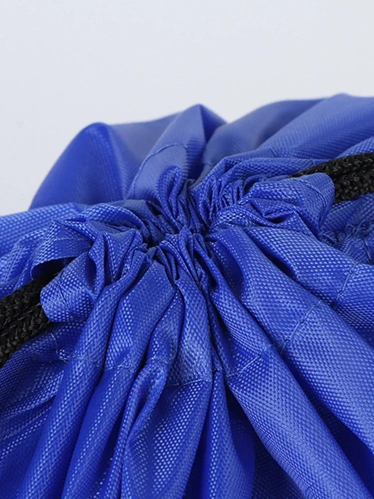 Close-up of a royal blue drawstring bag featuring a textured fabric and black cord closure.