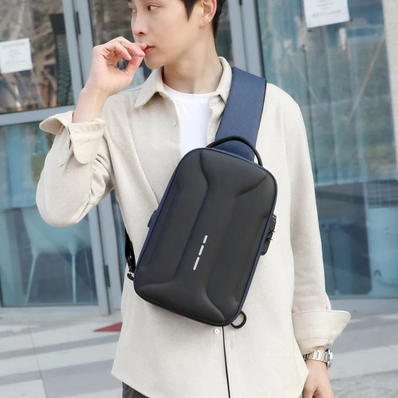 Man wearing a black and navy blue anti-theft crossbody bag with a sleek, moulded design and USB charging port.