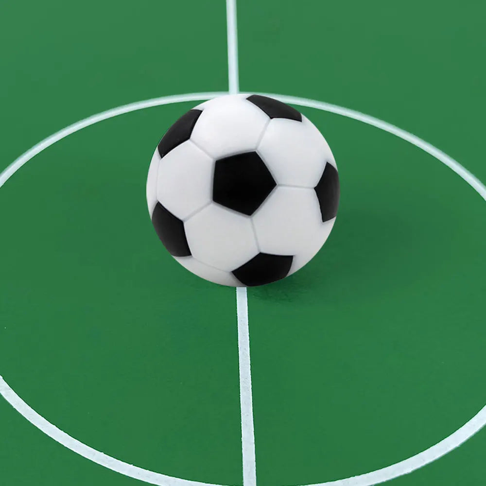 A classic black and white football resting on a green pitch marked with white centre circle and line.