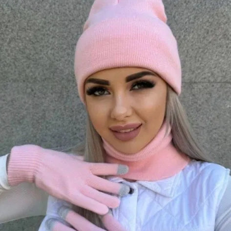 Woman wearing a soft pink knitted winter beanie and matching neck warmer.