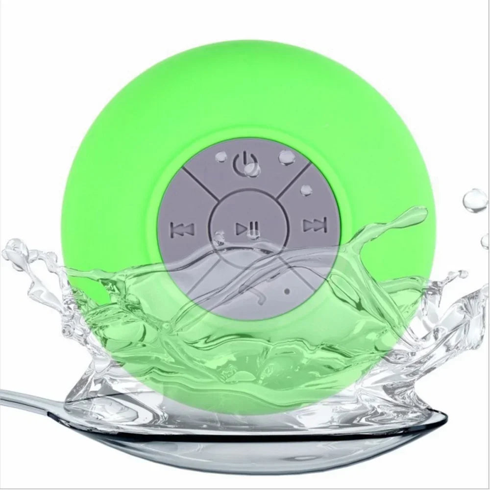 Bright green, circular waterproof Bluetooth speaker with a grey control panel, surrounded by a splash of water.