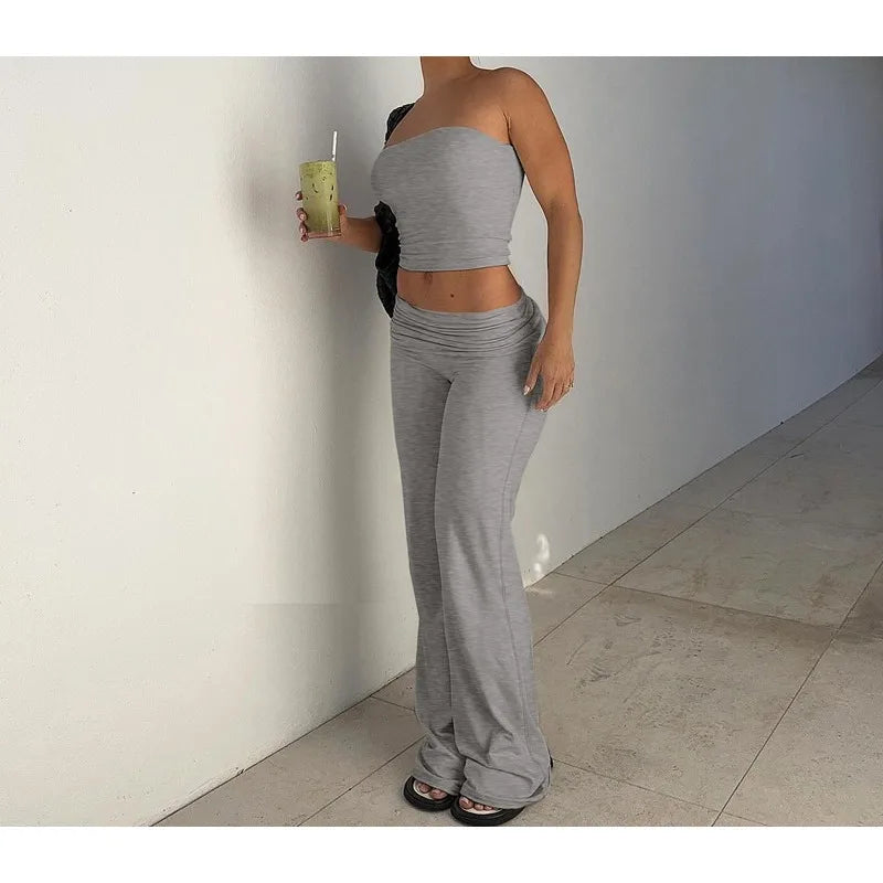 Grey two-piece set featuring a strapless crop top and matching high-waisted, flared jersey trousers.