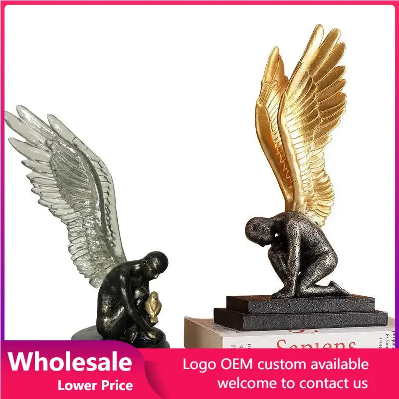 Two kneeling angel figurines, one with translucent wings and one with metallic gold wings on a black base.