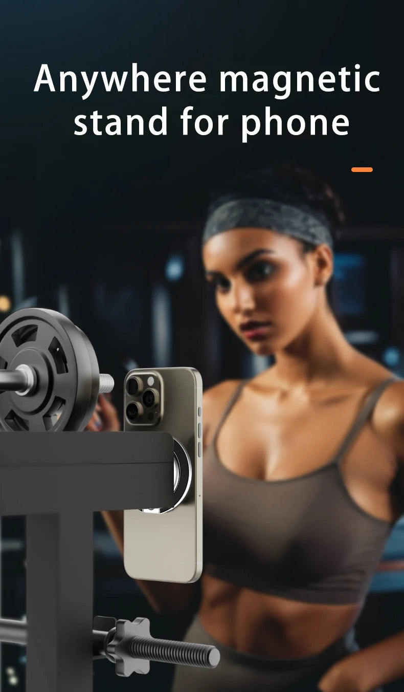 A sleek, circular silver magnetic phone stand attached to gym equipment, holding a smartphone vertically.