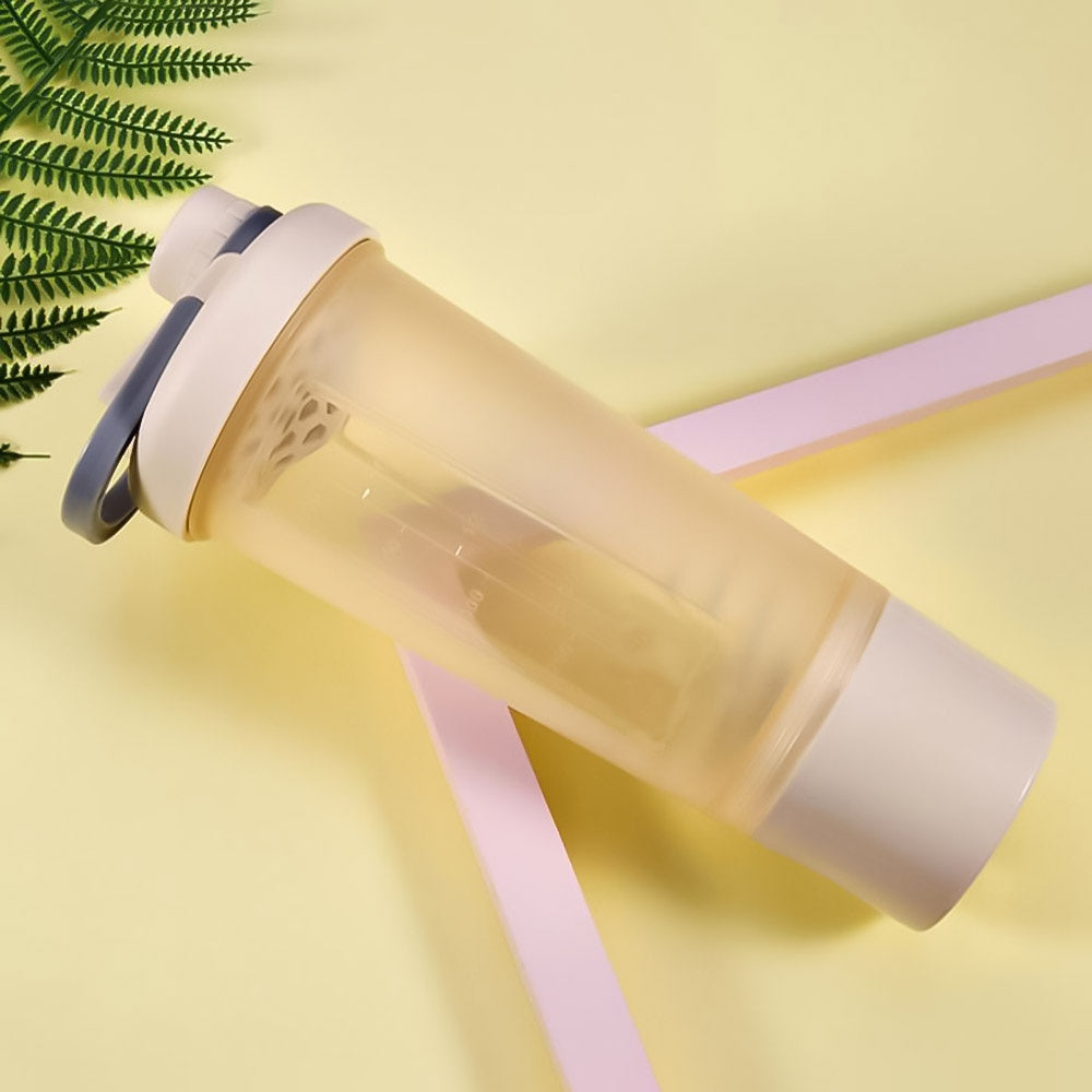 Translucent yellow shaker bottle with a cream lid, grey carry loop, and internal mixing insert on yellow background.
