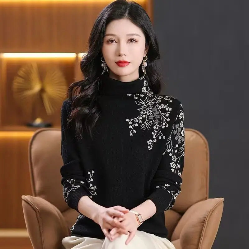 Black high-neck jumper with white floral embroidery detailing on the shoulder and sleeves.
