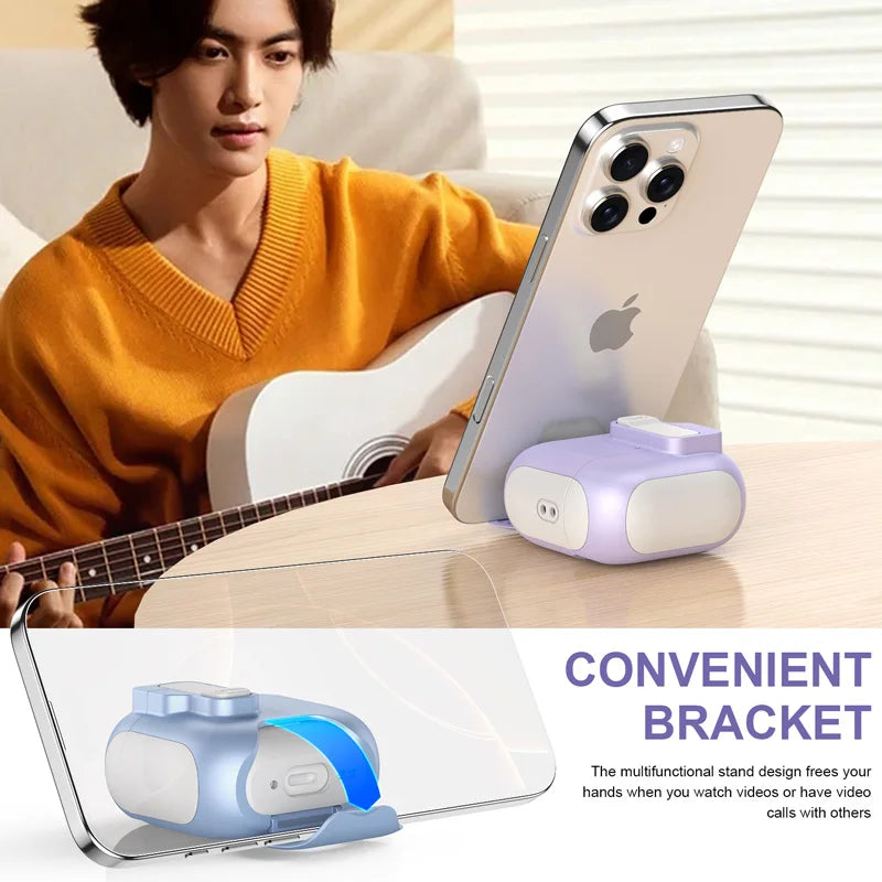 Purple silicone AirPods Pro case with integrated phone stand, shown supporting a smartphone on a table.