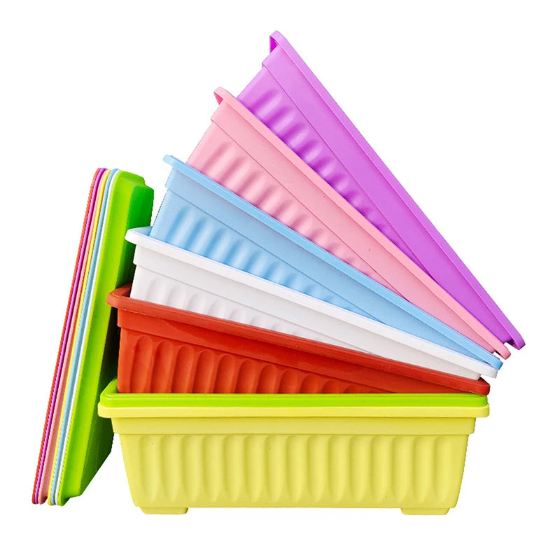 A stack of colorful, rectangular plastic planters with fluted sides, shown in assorted bright shades against white.