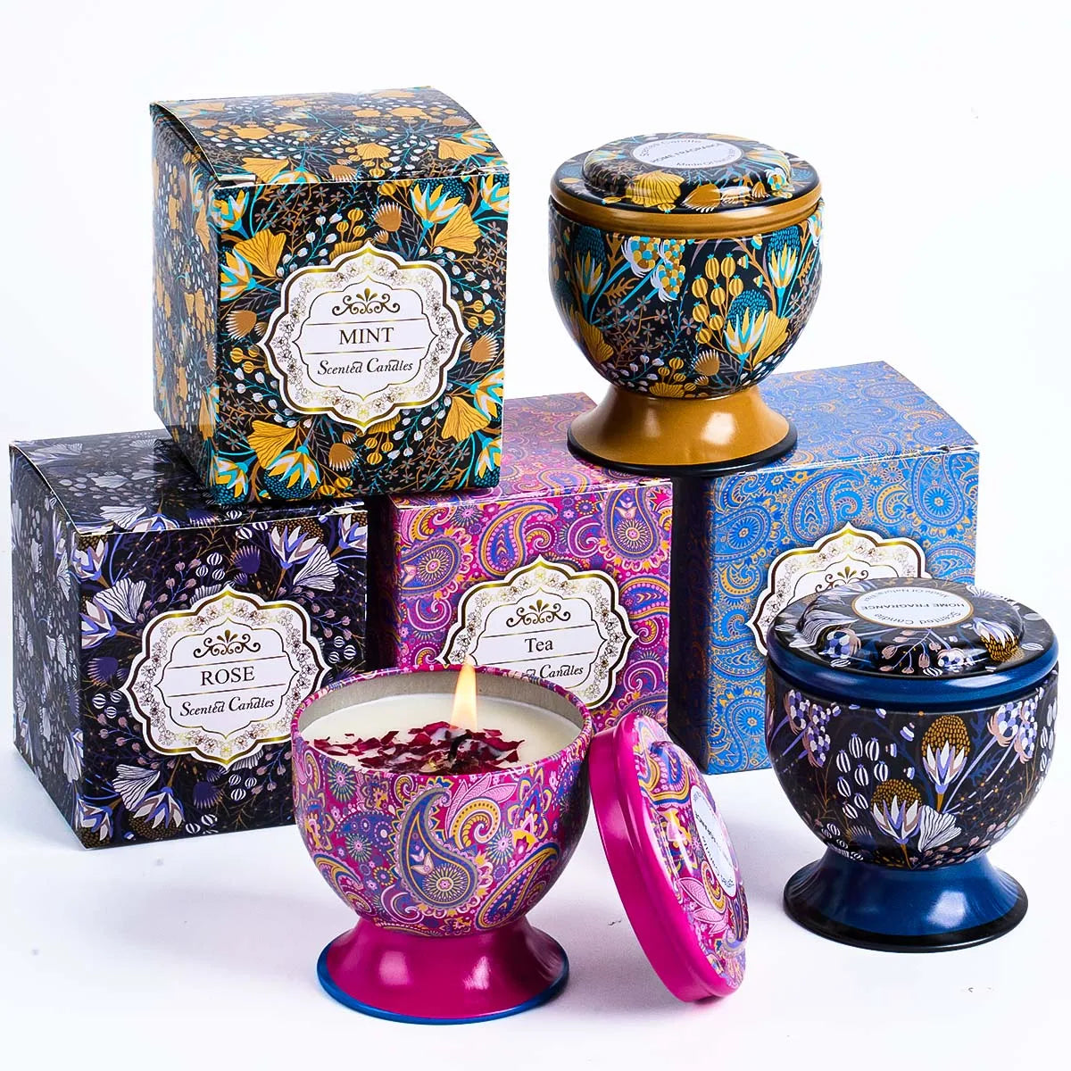 Set of patterned, footed metal tins with matching boxes. Includes lit candle and various floral and paisley designs.
