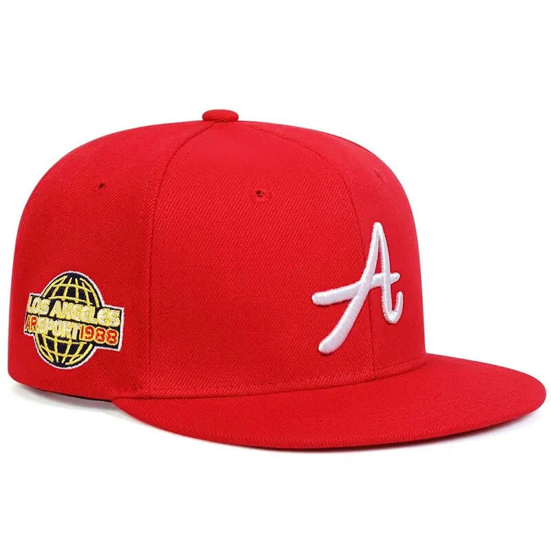 Bright red hip-hop baseball cap featuring a white embroidered letter 'A' and a globe side patch detail.