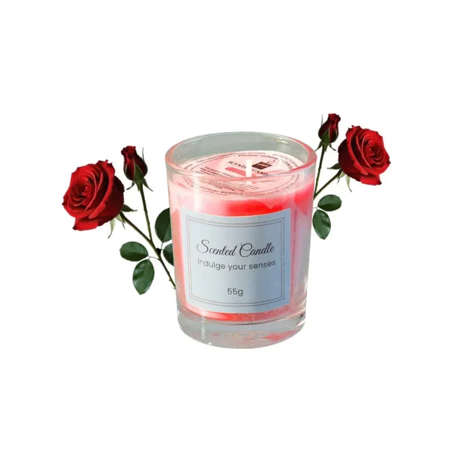 Red scented candle in a clear glass jar, accented with decorative red roses on a white background.