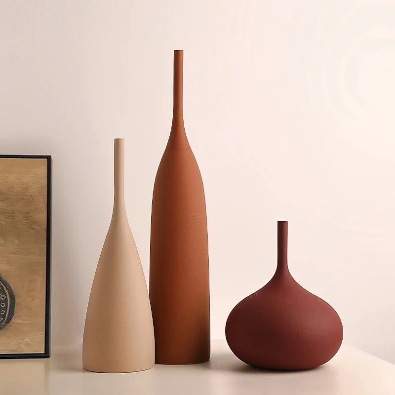 Three handmade ceramic vases in neutral, terracotta, and deep red with a minimalist, wabi-sabi aesthetic.