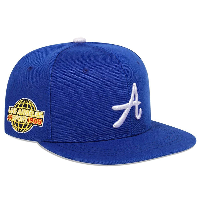 Royal blue baseball cap featuring a white gothic 'A' on the front and a globe-themed 'Los Angeles' side patch.