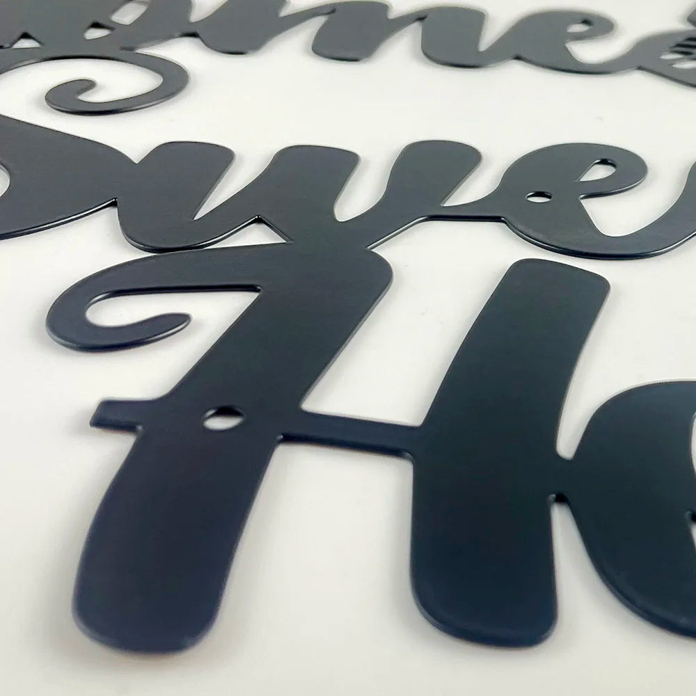 Matte black metal wall art reading 'Home Sweet Home' in a stylish, flowing script font.