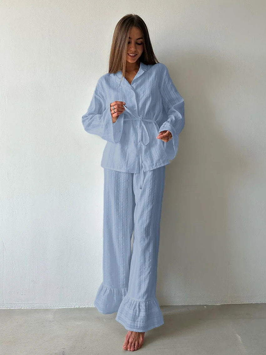 Blue textured lounge set with a belted button-up shirt and wide-leg trousers featuring ruffle hem details.