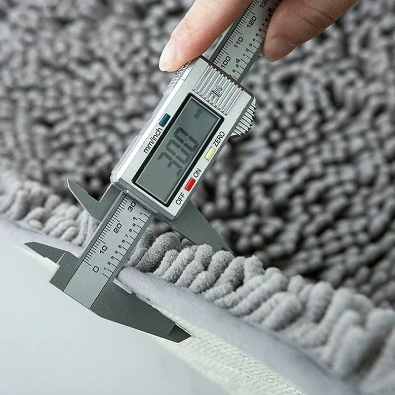 Close-up of a thick, grey absorbent dog doormat being measured with digital calipers to show its 30mm pile depth.
