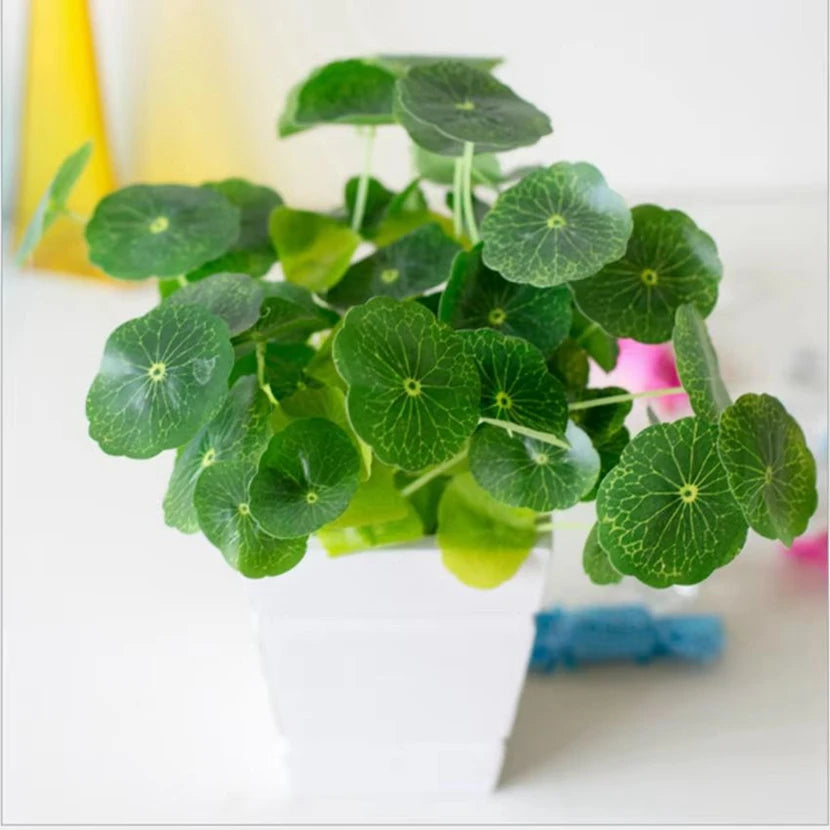 Artificial plant with round, veined green leaves in a simple, square white pot.