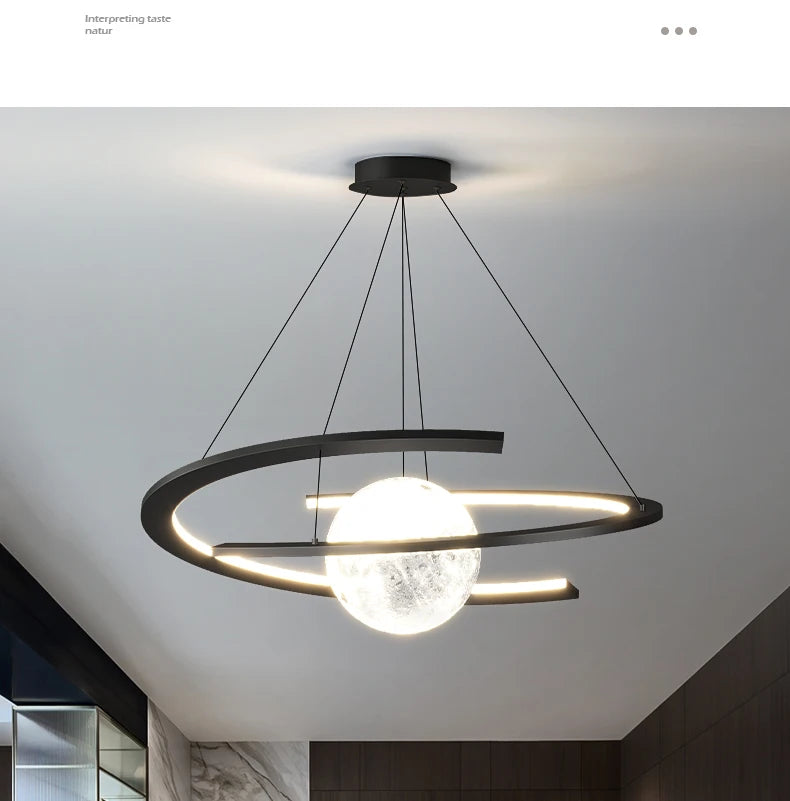 Modern matte black pendant lamp featuring a luminous, textured moon-like globe centred within an orbiting LED ring.