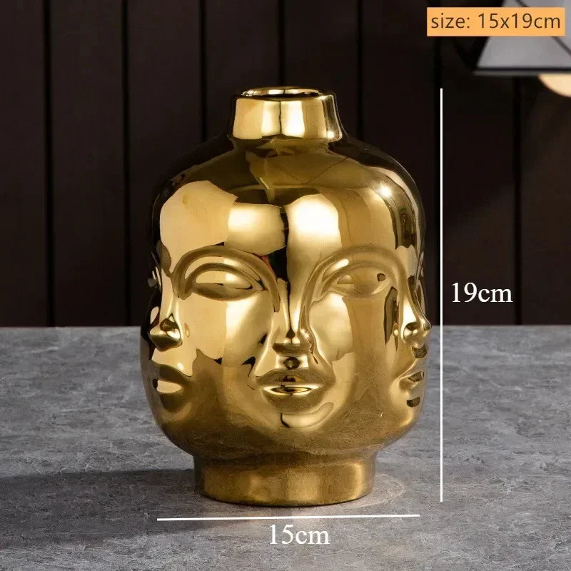 Metallic gold ceramic vase featuring a sculpted multi-face design, 15cm x 19cm.