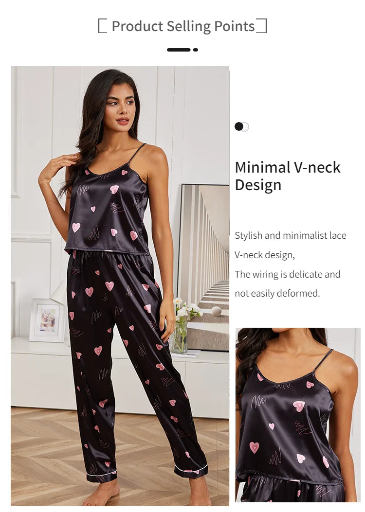 Black satin pyjama set with pink heart pattern, featuring a V-neck camisole and matching trousers.