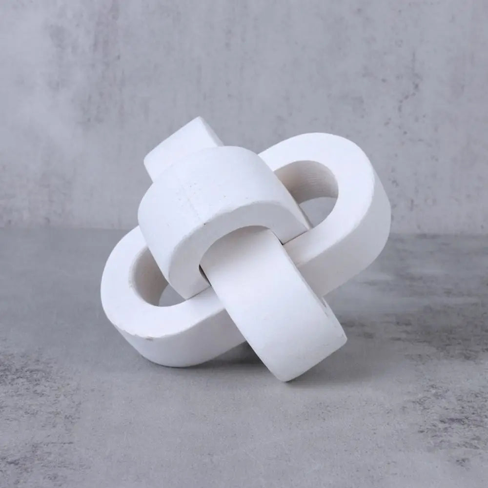 Modern white matte decorative sculpture featuring interlocking circular links on a grey background.