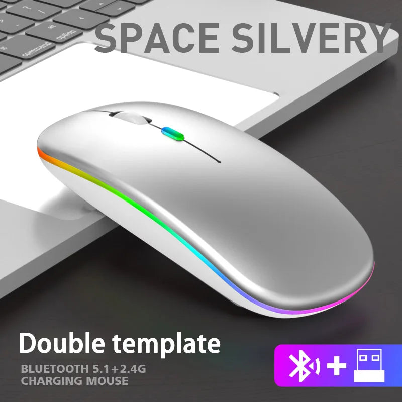 Slim, silver ergonomic wireless mouse with rainbow LED lighting, placed next to a laptop.