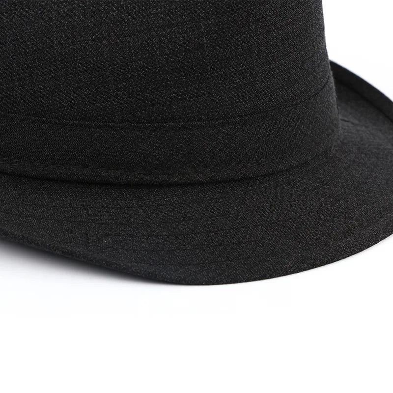 Close-up of a classic black textured fedora hat with a matching ribbon band.