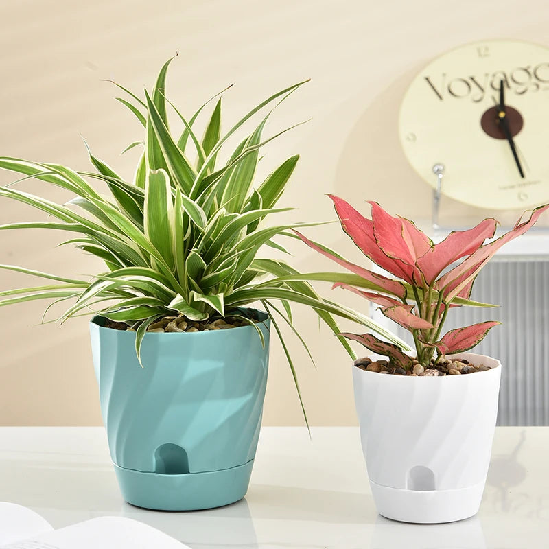 Two modern, spiraled plastic flower pots in turquoise and white, each featuring a bottom drainage port on a table.