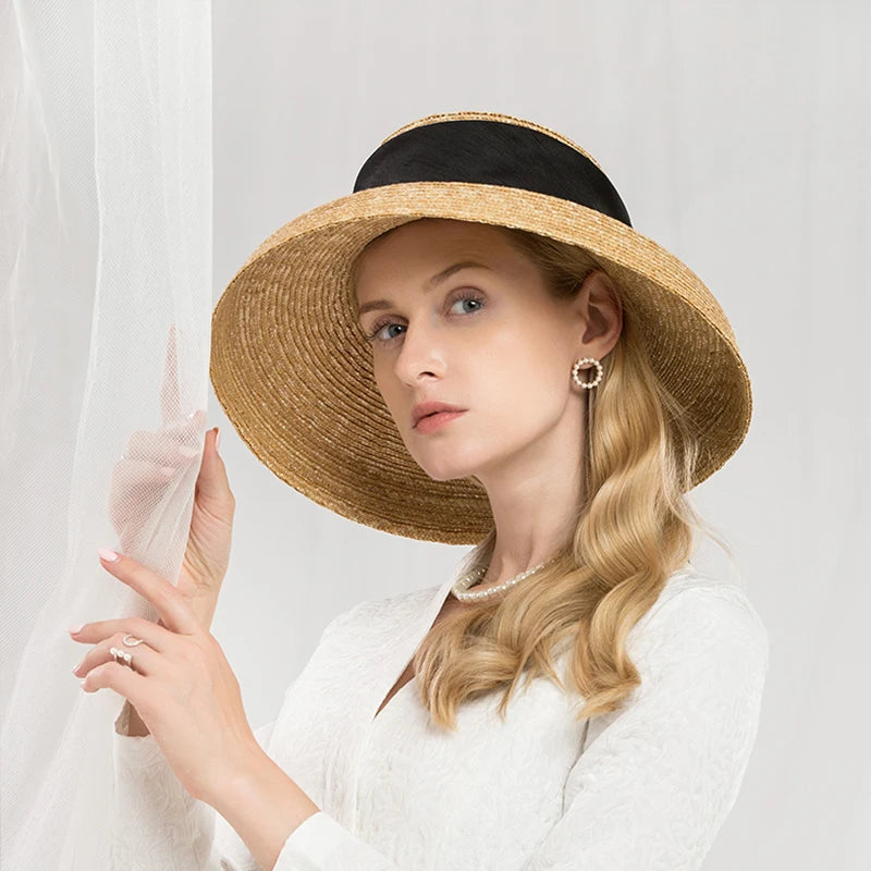 Elegant wide-brim straw sun hat in natural tan featuring a classic black ribbon band.