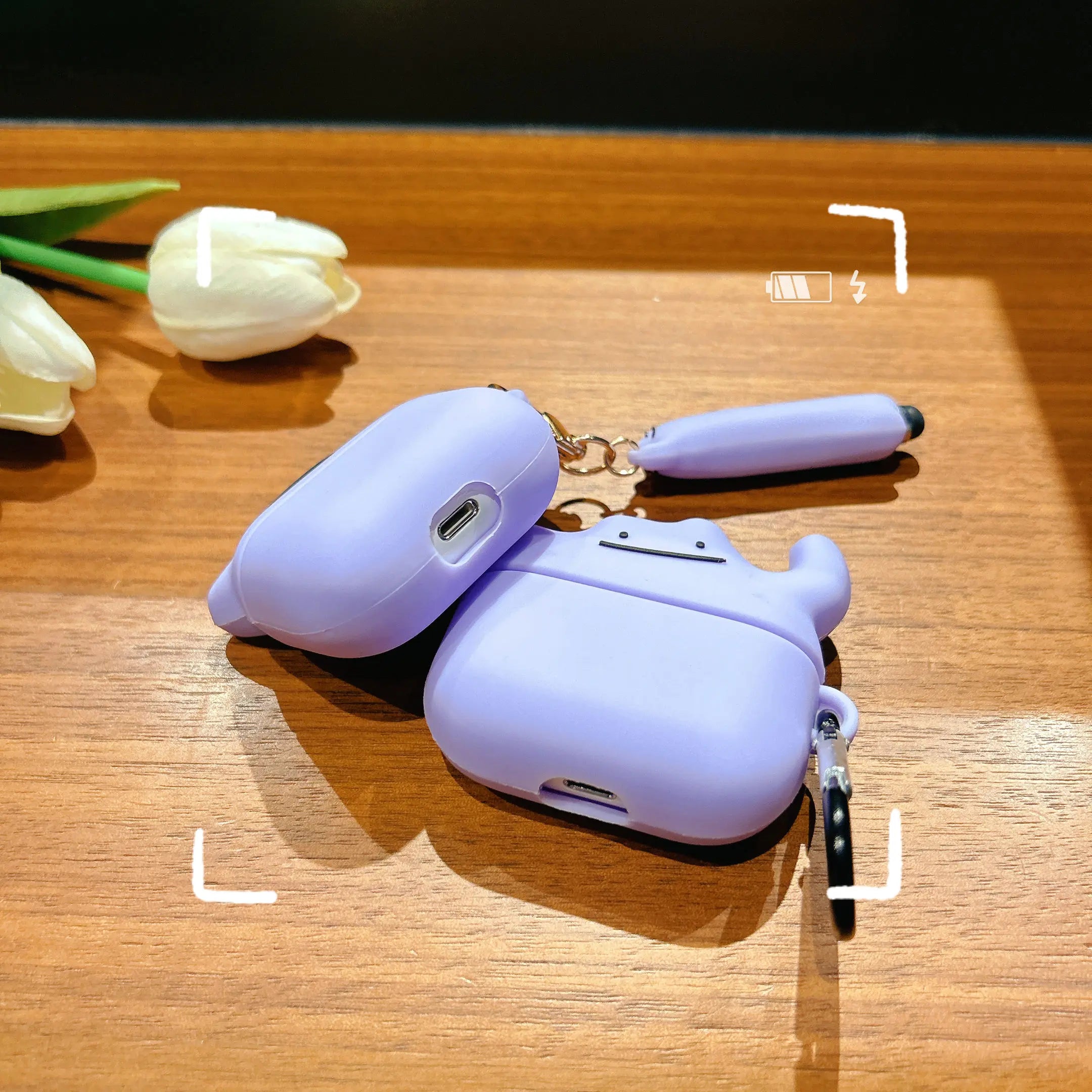 Lilac silicone AirPods Pro case with a cute Ditto character design, featuring a matching charm and keychain.