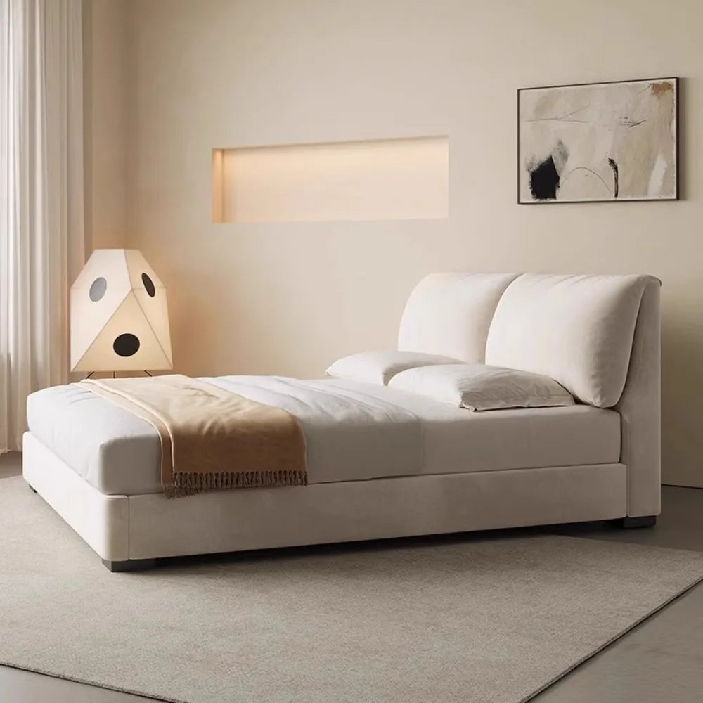 Modern cream upholstered storage bed with a plush, split-cushion headboard, styled in a minimalist bedroom.