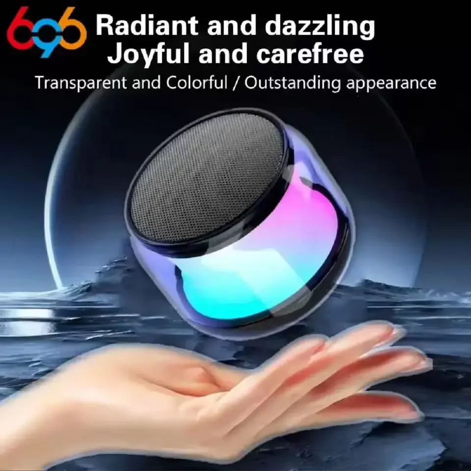 Small, portable wireless speaker with a transparent casing and colourful LED lighting, held in a palm.