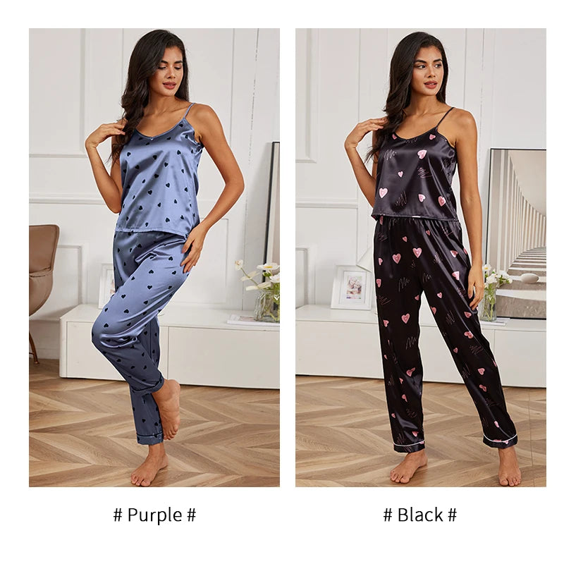 Two sets of satin pyjamas with camisole tops and trousers, featuring heart prints in purple and black colourways.