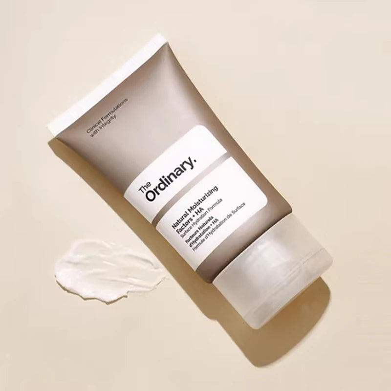 Taupe-coloured squeeze tube of face moisturizer with a white label and a swatch of white cream beside it.