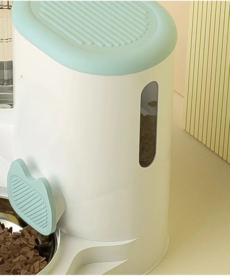 Modern white and mint green automatic pet feeder with a food-level viewing window and stainless steel bowl.