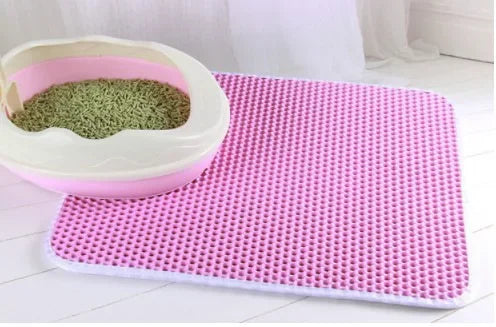 Pink honeycomb-patterned double-layer cat litter mat next to a matching pink litter tray.