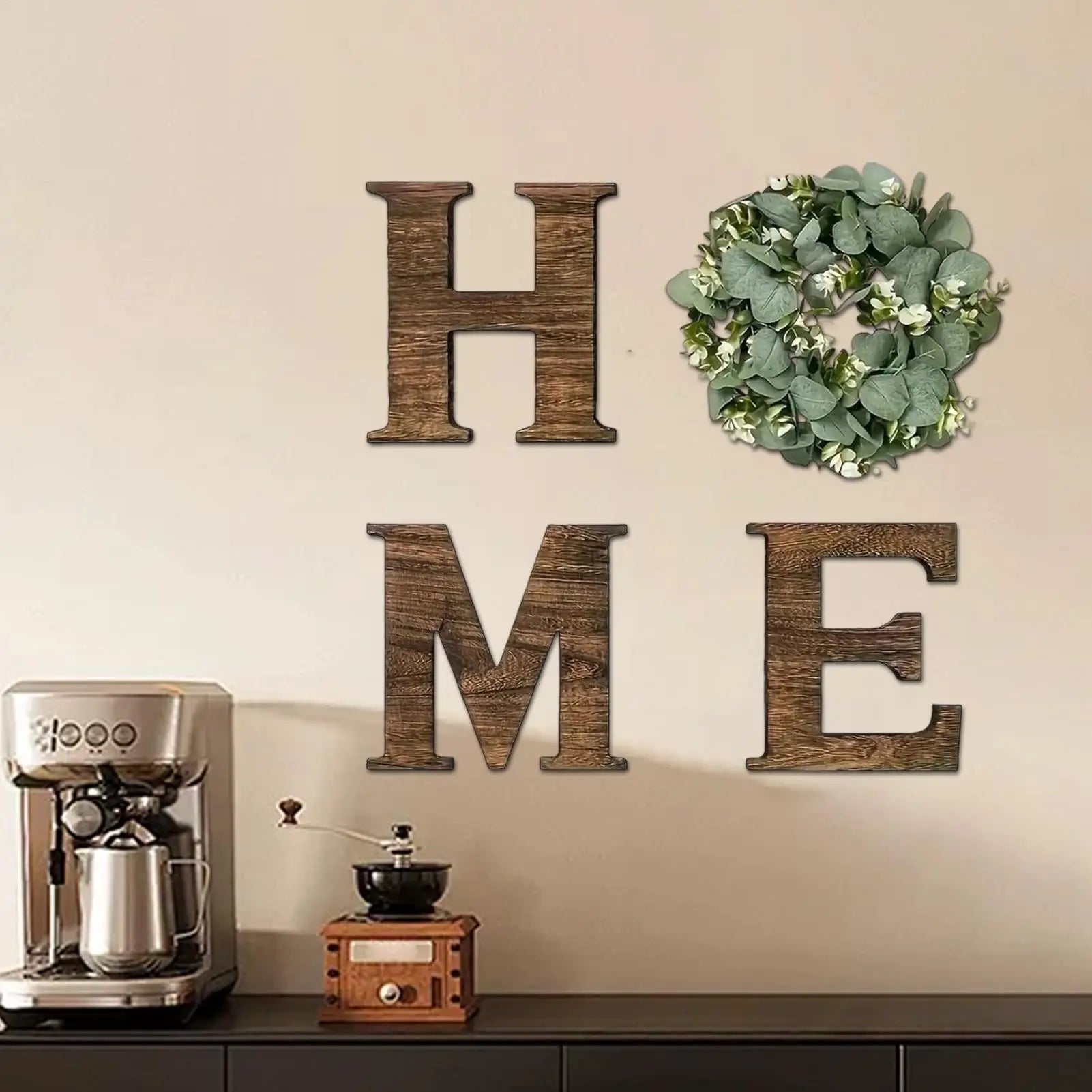 Rustic wooden 'HOME' wall sign with the 'O' replaced by a decorative artificial eucalyptus wreath.