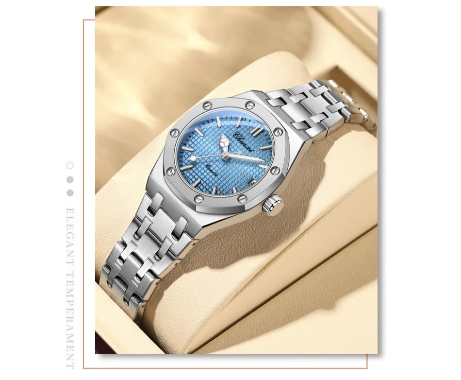Luxury silver stainless steel women’s watch with a textured light blue dial and screw-detail bezel, displayed in a box.